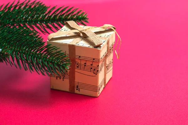 Noel kartı. Pembe arka planda hediyeli bir Noel ağacının düz dalları. Kopyalama alanı ile kapat