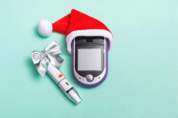 Tatil süslemeleri, Noel Baba şapkası ve kan şekeri sayacı olan bir Noel afişi. Kopya alanı olan doktorlar için Noel kartı kavramı.