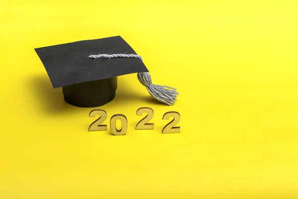 Gift box in the form of a graduation cap. 2022 release concept on yellow background with copy space