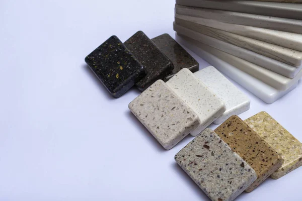 Samples of natural granite, marble, quartz stone, countertops and a sample of natural parquet. Model made of stones, close up. Modern colored slabs made of natural stone.