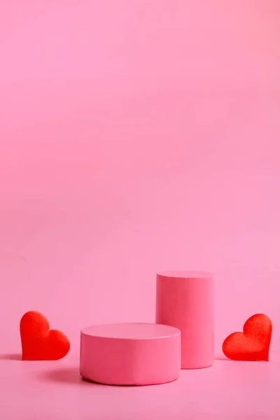 Hintergrund zum Valentinstag mit Podesten für Produkte oder Kosmetik mit Herzen auf rosa Hintergrund. Nahaufnahme. Vertikales Format — Stockfoto