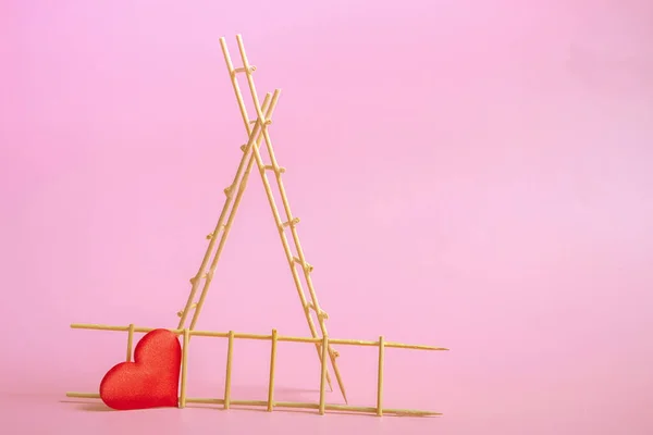Holzleiter mit roten Herzen auf rosa Hintergrund. Postkarte oder Einladungsvorlage. Nahaufnahme — Stockfoto