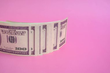 Pembe arka planda 100 dolarlık banknotlar, fotokopi alanı ile kapatın.