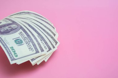 Pembe arka planda 100 dolarlık banknotlar, fotokopi alanı ile kapatın.