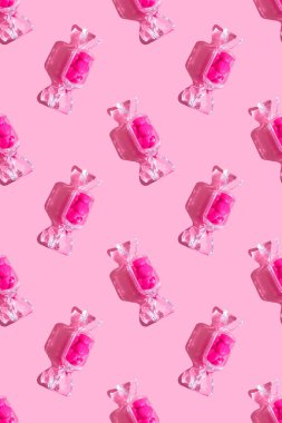 Şeffaf şeker şeklindeki kutuda tatlı kalp lolipopları ve pembe arka planda sert gölgeli fotokopi alanı var. Sevgililer Günü konsepti, anneler günü. Pankart. Desen dikey biçimi