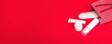 Kırmızı arka planda kozmetik manzaralı bir hediye çantası var. Sevgililer günü konsepti, anneler günü, indirim. Kopyalama alanıyla, yakın çekim. Pankart