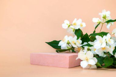Kozmetik ürünleri ve çeşitli ürünleri yaseminli bej bir arka planda yakın planda sergilemek için üçgen podyum.