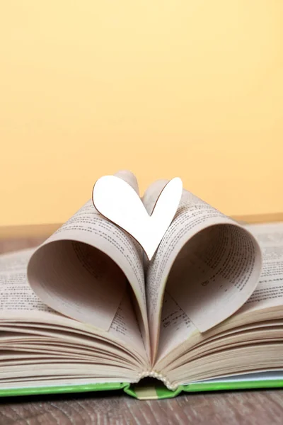 Ein Aufgeschlagenes Buch Mit Einem Holzherz Auf Dem Tisch Konzept — Stockfoto