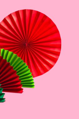 Kağıt renkli fanlar ve metin için fotokopi alanı olan pembe arkaplan. Dikey Biçim
