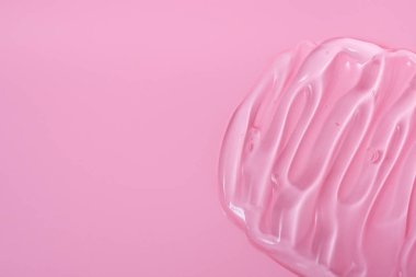 Pembe arka planda cilt bakımı için jel makyaj malzemeleri, krem, kabuk soyma, süt, losyon, damla dokusu. Kopyalama alanı ile yakınlaş.