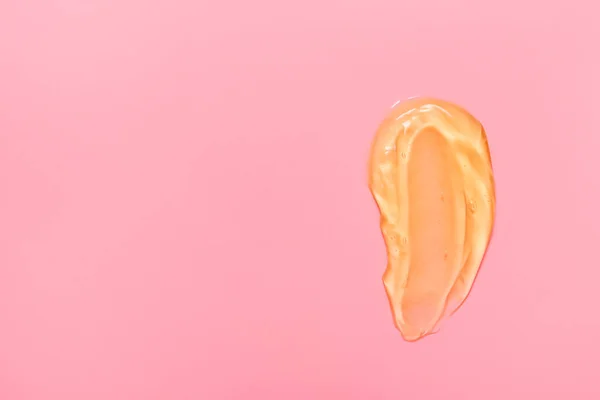 Gel cosmetische uitstrijkjes voor huidverzorging op een roze achtergrond, crème, peeling, melk, lotion, druppels textuur. Close-up met kopieerruimte. — Stockfoto