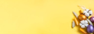 Paskalya bayrağının üst görüntüsünü kapat. Sarı arka planda Paskalya yumurtası, pamuk ve laguru. Kopyalama alanı olan pankart