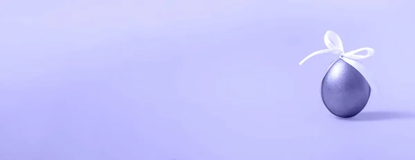 非常にパーイの背景に白い弓でイースター紫色の卵 コピースペースを閉じます バナー — ストック写真
