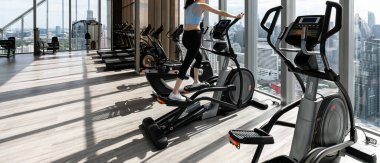 Spor salonunda egzersiz yapan güzel bir kadının arka görüntüsü.