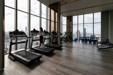 Spor salonunda egzersiz yapan güzel bir kadının arka görüntüsü.