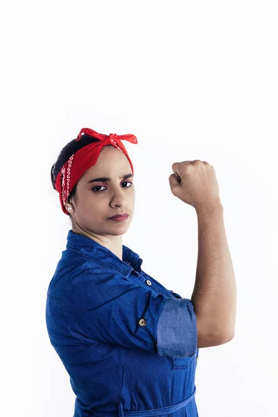 Feminist kadın beyaz arka planda ciddi bir şekilde kolunu gösteriyor.