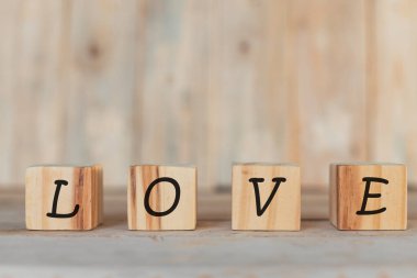 Tahta bloklar, seni seviyorum sözüyle yatay, ahşap bir arka planda.