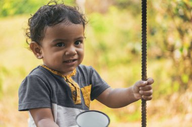 Latin çocuk beyaz bir fincanda kahve içiyor, doğal bir ortamda.