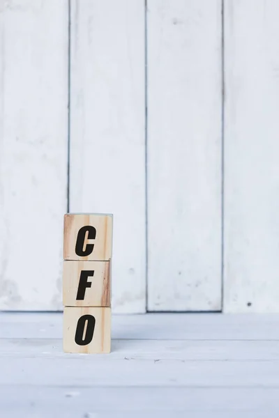 Conceito cfo escrito em cubos ou blocos de madeira, sobre fundo de madeira branco. — Fotografia de Stock