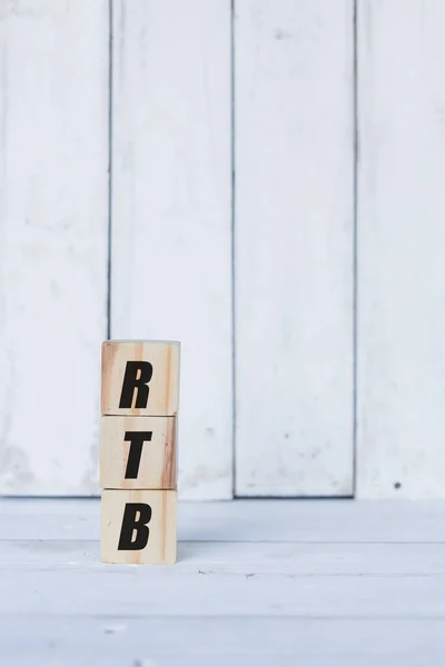 Conceito rtb escrito em cubos ou blocos de madeira, sobre fundo de madeira branco. — Fotografia de Stock