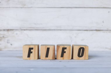 Tahta küplere ya da bloklara, beyaz ahşap arka plana yazılmış Fifo kavramı.