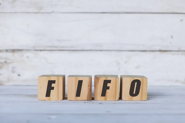 Conceito de Fifo escrito em cubos ou blocos de madeira, sobre fundo de madeira branco. — Fotografia de Stock
