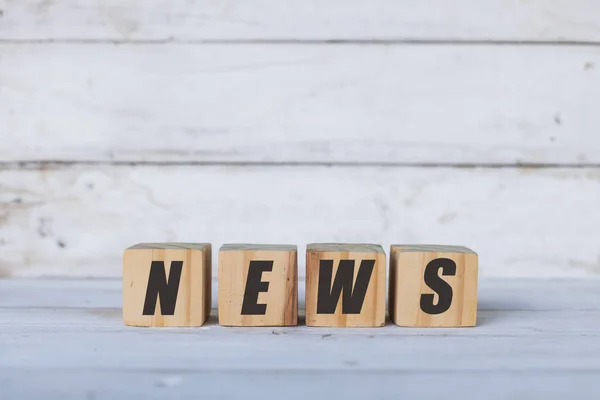 Tahta küplere ya da bloklara, beyaz ahşap arka plana yazılmış haber kavramı.