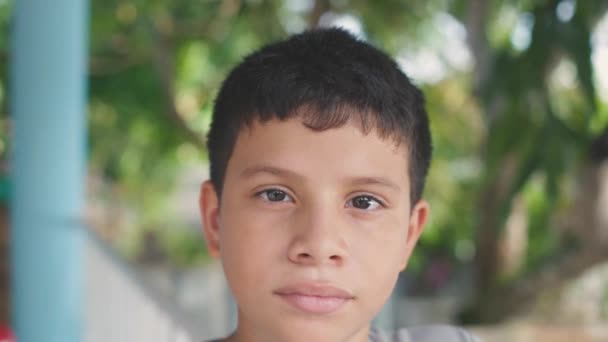 Hispanic young man looking at camera, close-up. — Video