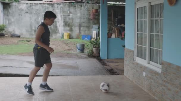Latin garçon coups de pied la balle contre le mur, à la maison — Video