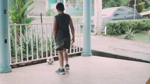 Latinský chlapec kopání míč na zábradlí — Stock video