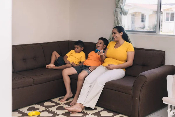 Aile, çikolata sandalyesinde oturup televizyon seyrediyor.