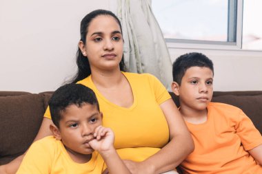 Aile, çikolata sandalyesinde oturup televizyon seyrediyor.