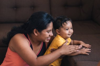 Anne yere otur ve bebeğiyle oyna.