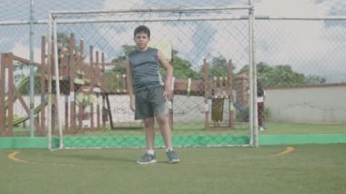 Latin çocuk topu alıyor ve tekmeliyor..