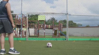 çocuk topa vuruyor, kaleye, geriye.