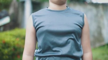 Latin çocuk kameraya bakıyor, nefes alıyor, orta düzlemde..