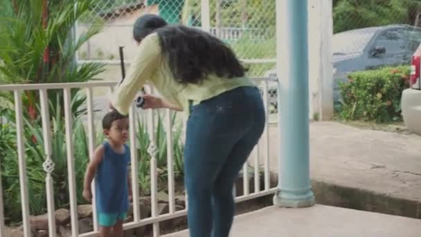 Latin Mother Putting Headphones Her Son Terrace House Medium Shot — Wideo stockowe