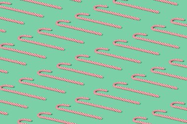 Kırmızı Noel bastonlarıyla yaratılmış yaratıcı desen. Asgari nane yeşili yeni yıl partisi geçmişi.