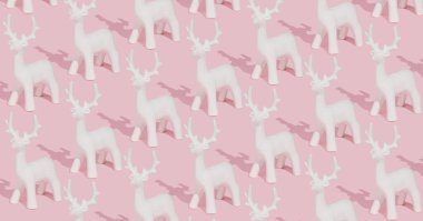 Pembe arka planda beyaz ren geyiği süslemelerinden yapılmış yaratıcı pastel pembe kış deseni. Moda Noel kompozisyonu.