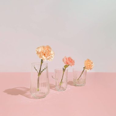 Çiçekli, vazolu ve kristal bardaklı modern pastel pembe kompozisyon. Asgari tarz romantik estetik.