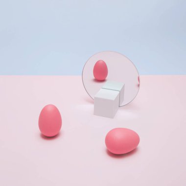 Pembe yumurtalar ve ayna yansıması olan modaya uygun Paskalya konsepti. Eğlenceli, asgari estetik.