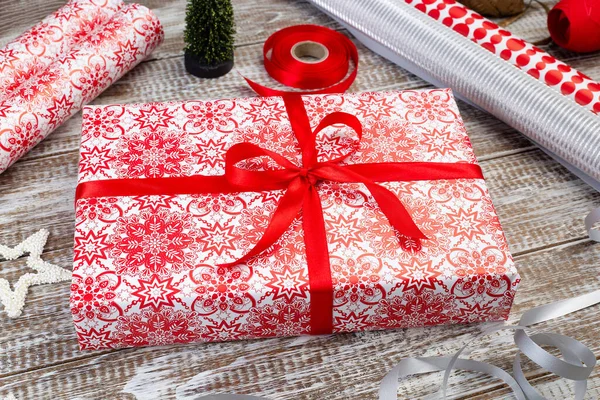 Geschenkbox mit Geschenkpapier und Bändern auf dem Tisch — Stockfoto