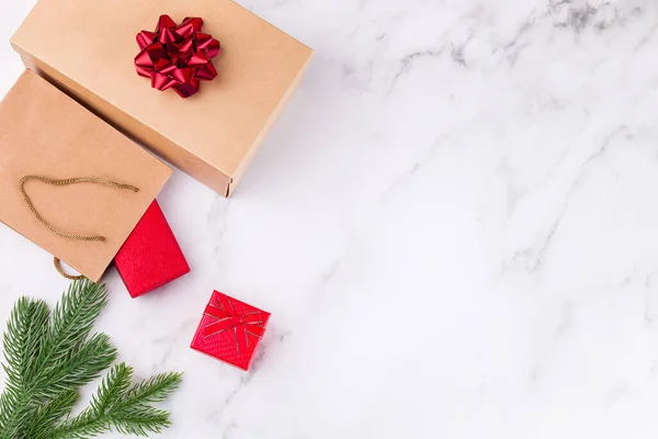 Caixas de presente ou pacotes e ramo de abeto em um fundo de mármore. Compras de presentes de Natal ou preparação — Fotografia de Stock
