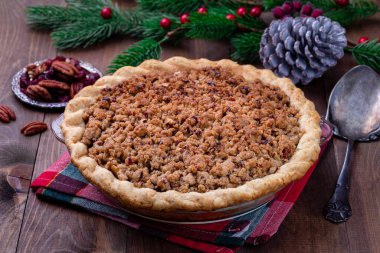 Taze pişmiş Amerikan elmalı yaban mersinli turta, üzeri parçalanmış hamur ve cevizli, pişirme kabında.