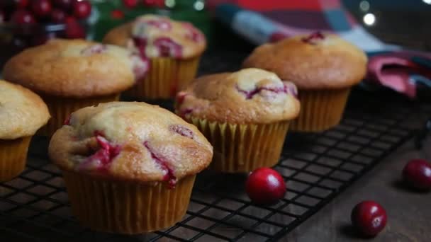 Revers dolly shot with homemade cranberry orange muffins on cooling rack, Christmas decoration on background — Stock Video