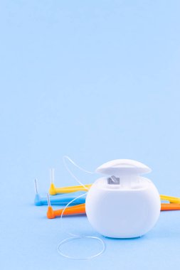 Mavi arkaplanda diş ipi ve interdental fırça açıları, dikey, kopyalama alanı