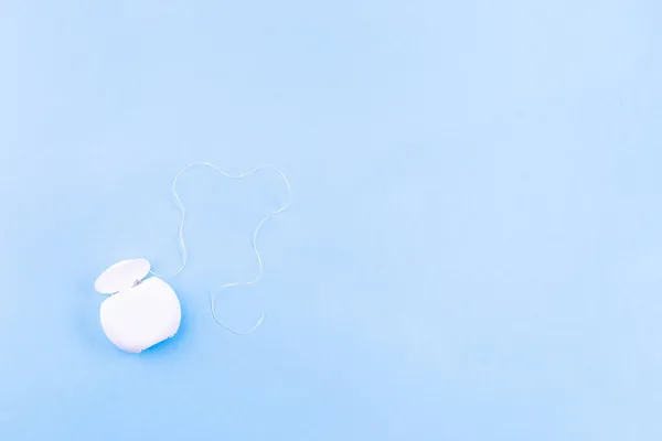 Zahnseide auf blauem Hintergrund, Kopierraum, waagerecht — Stockfoto