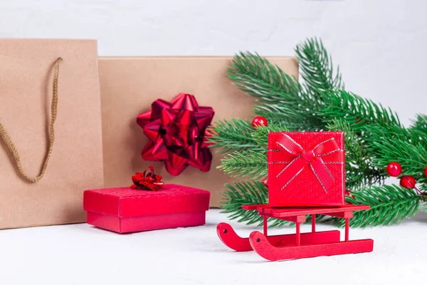 Caixa de presente vermelho no trenó de Santa, ramos de árvore de Natal, caixas de presente e sacos no fundo, horizontal — Fotografia de Stock