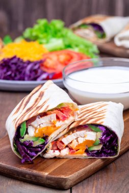 Kızarmış tavuk dürümü, kırmızı lahana, avokado, domates, marul, çedar peyniri.