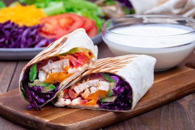 Kızarmış tavuk dürümü, kırmızı lahana, avokado, domates, marul, çedar peyniri, yatay